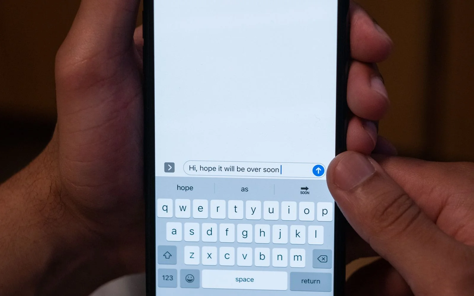 Hands holding a smartphone with a messaging app open