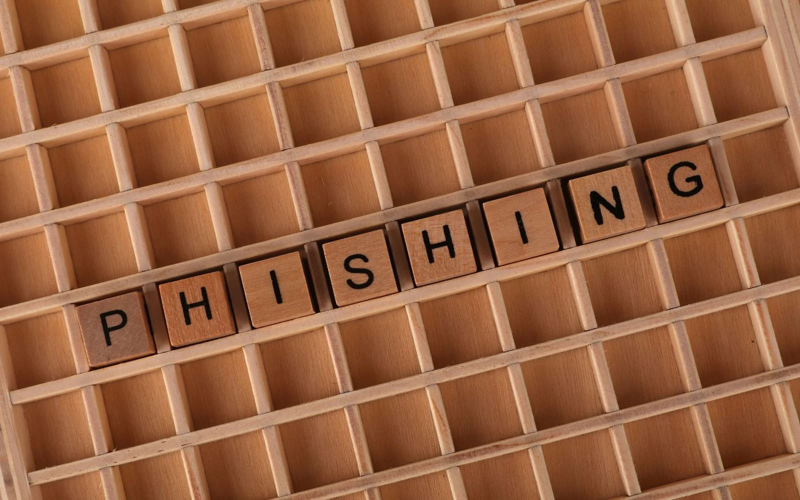 Wooden letter tiles spelling the word phishing