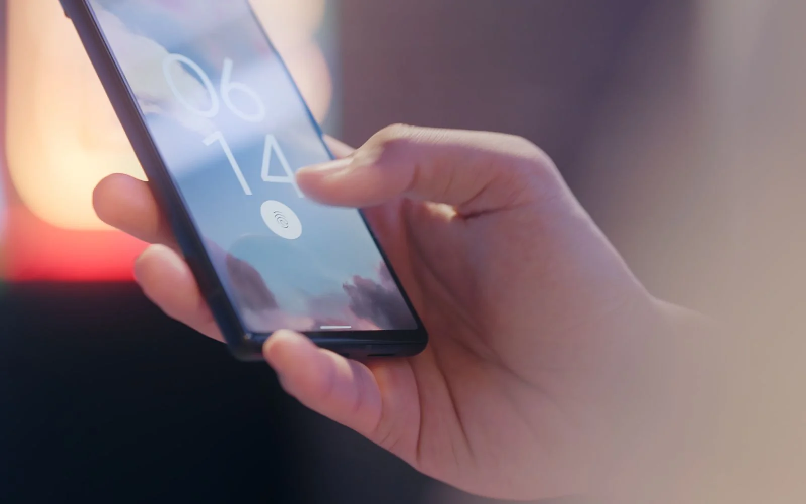 A hand holding a smartphone locked with a fingerprint sensor