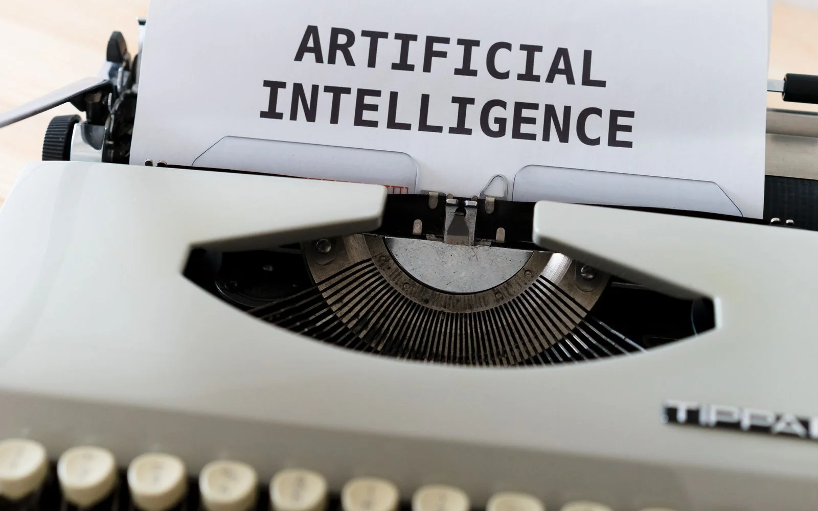 A typewriter with the words artificial intelligence typed on paper